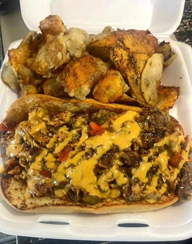Philly loaded with steak, peppers and onions under a heavy queso drizzle, with fried taters